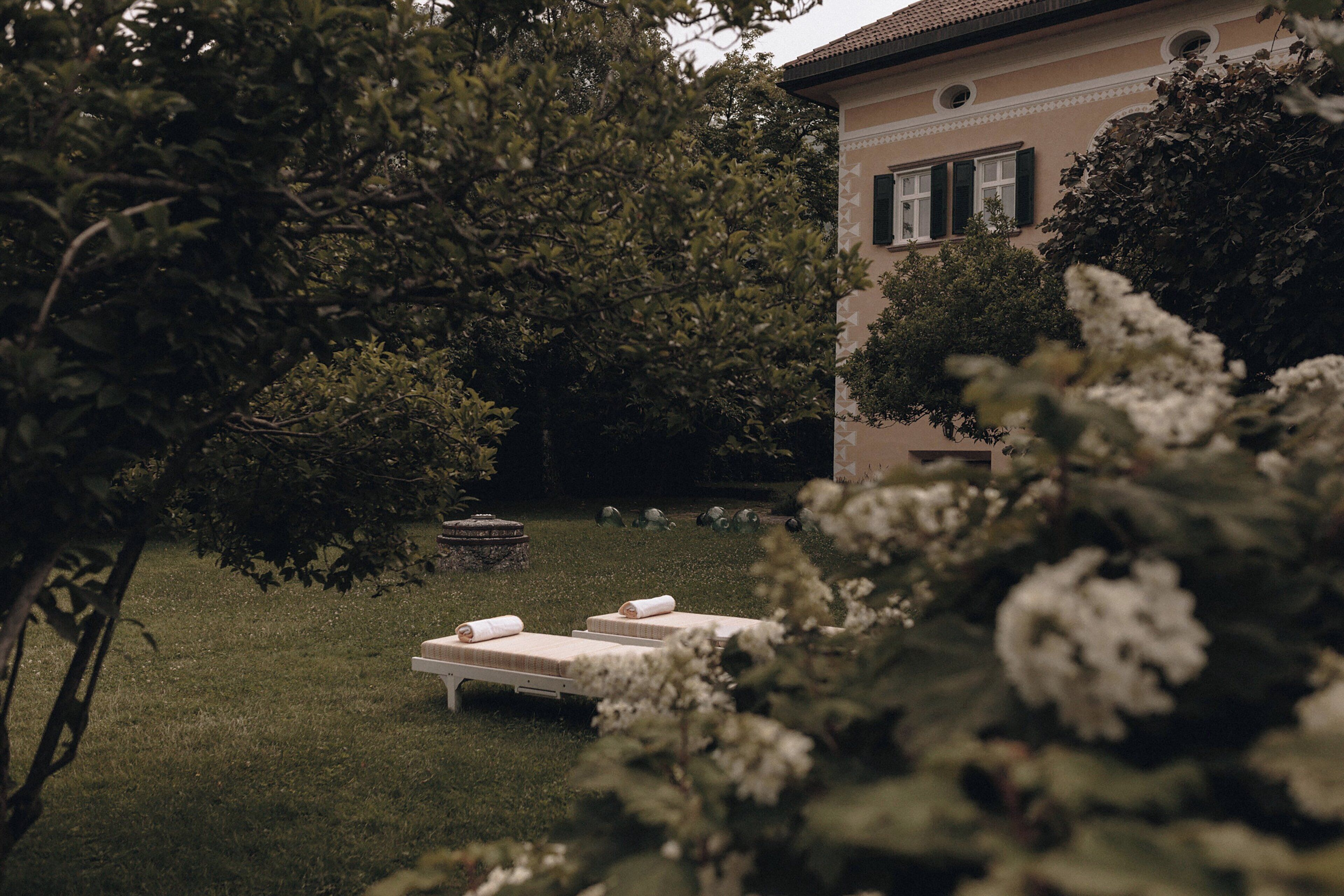Un jardin avec deux chaises longues et une fontaine.