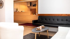 A modern hotel lobby with a reception desk, a black sofa, and a white armchair. - 4-Room Rental with Balconies for 8 in Puy-Saint-Vincent (Puy-Saint-Vincent)