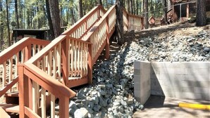 A wooden staircase leading to a building surrounded by trees. - Mama Bears Cabin (Ruidoso)