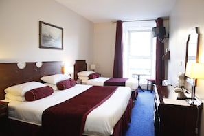A hotel room with two beds, a television, a desk with a lamp, and a window with curtains. - The Loft (Ballina)