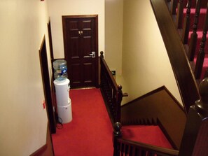 A staircase with a red carpet leading to a door. - The Loft (Ballina)