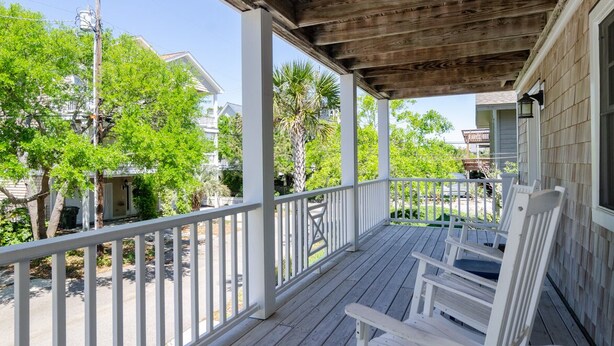 A wooden porch with white railings and two white rocking chairs. - Gorgeous Home 1 Block from Ocean and Banks Channel (Wrightsville Beach)