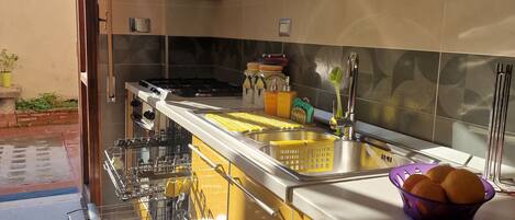 Kjøleskap, kokeplater, høy barnestol og kjøkkenutstyr