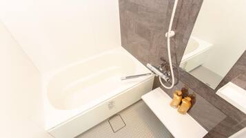 A modern bathroom with a bathtub, a shower, and a vanity with toiletries.