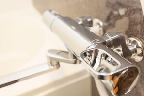 Kombination af bruser/badekar, hårtørrer, bidet, håndklæder