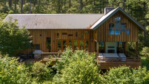 A wooden cabin with a large deck, multiple windows, and a chimney. - Orcas Island, Cedar Sunrise #222 (Orcas Island)