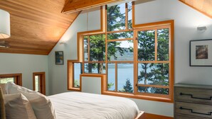 A bedroom with a large window, wooden ceiling, and a bed with pillows. - Orcas Island, Cedar Sunrise #222 (Orcas Island)