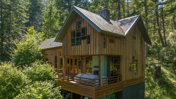 A wooden cabin with a balcony, surrounded by dense forest. - Orcas Island, Cedar Sunrise #222 (Orcas Island)