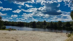 A beach with a lake, trees, and a clear sky. - Awesome HotTub,Pool,Firepit,Jacuzzi,Ev Charger (long pond)