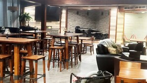 A restaurant with wooden tables and chairs, a counter with a menu, and a brick wall in the background. - Awesome HotTub,Pool,Firepit,Jacuzzi,Ev Charger (long pond)