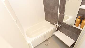 Een bad/douchecombinatie, een haardroger, een bidet, handdoeken