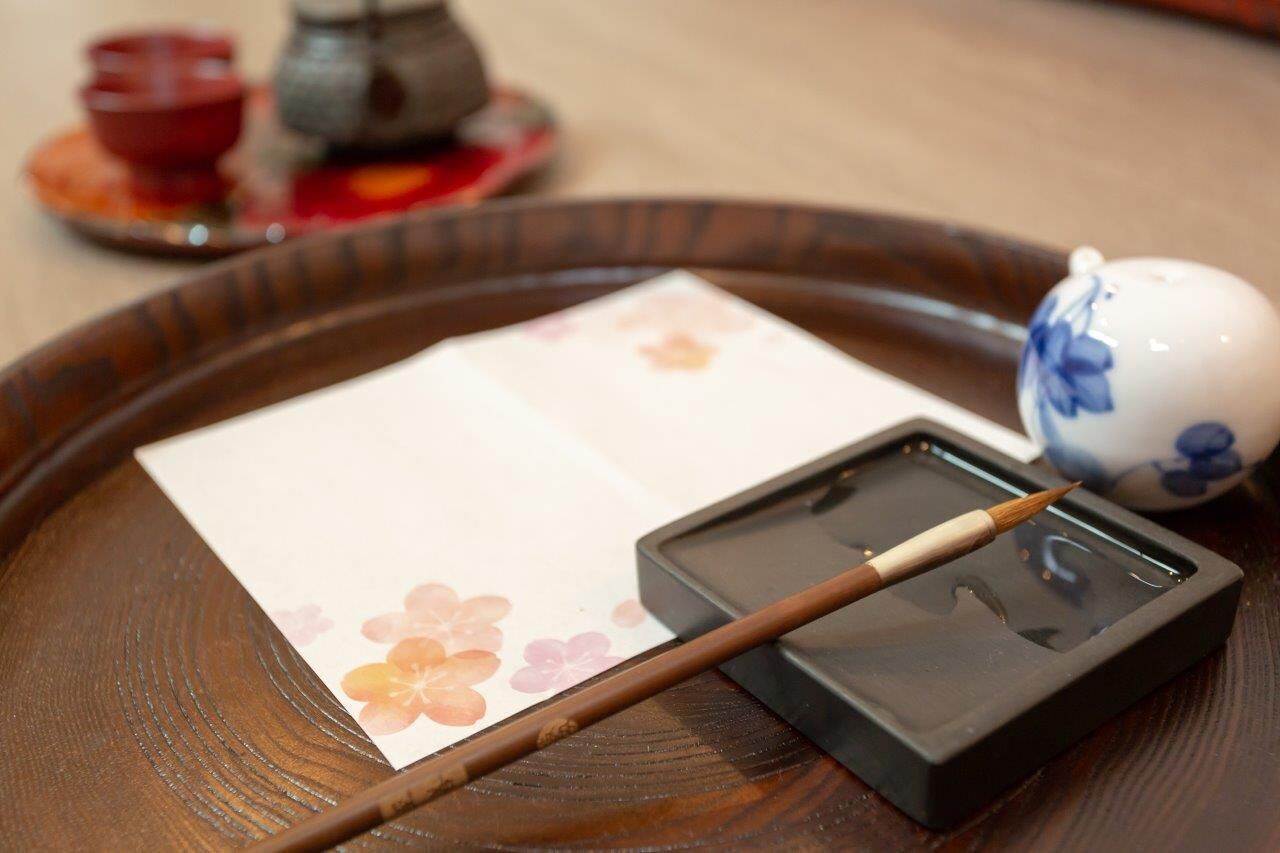 A tray with a tea set, including a teapot, cups, and a brush.