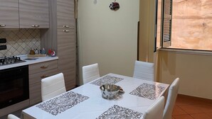 A kitchen with a dining table set for four, a stove, and cabinets.