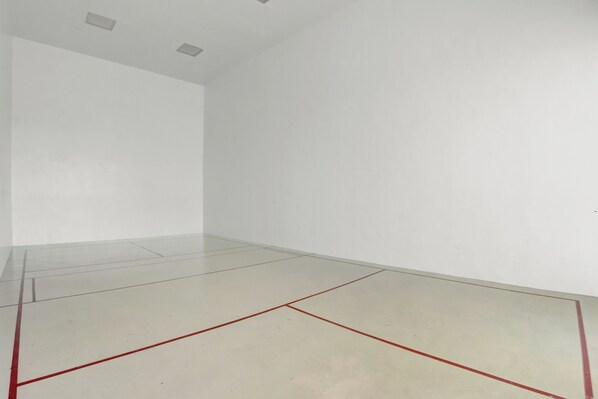 Een kamer met witte muren en een vloer met rode lijnen, waarschijnlijk een sportveld.