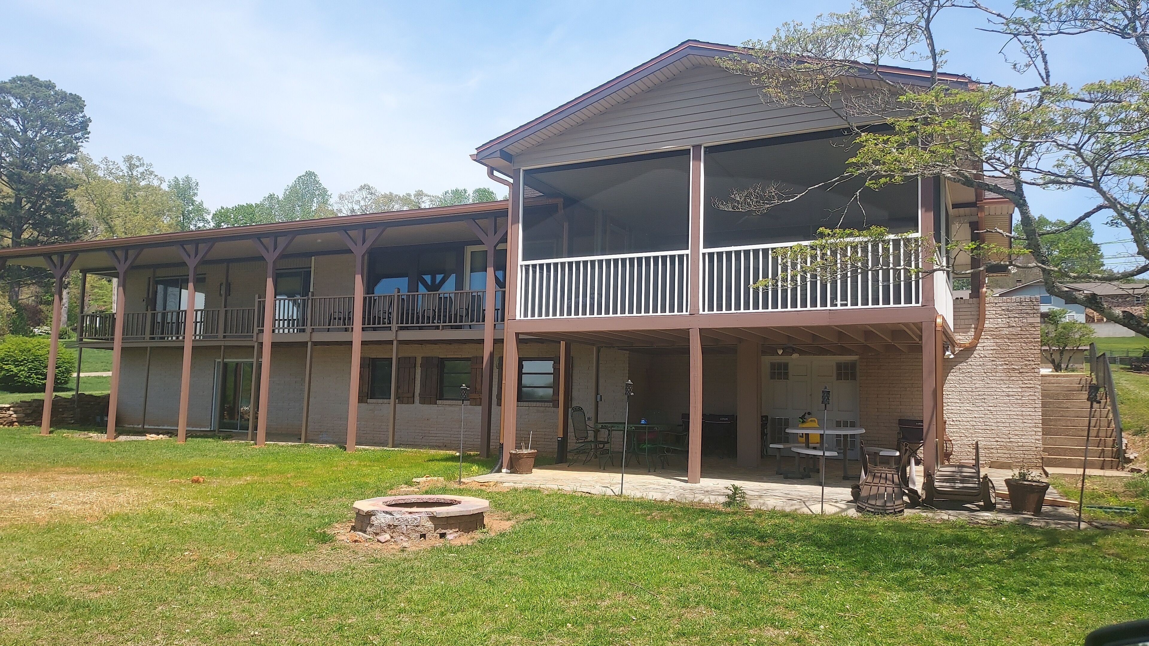 A two-story building with a covered patio area, a fire pit, and a small outdoor seating area.