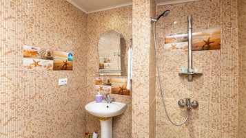 Chuveiro, secador de cabelo, toalhas de banho, papel higiênico