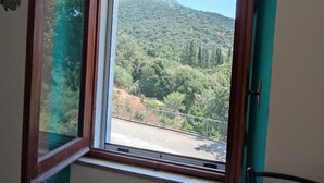 A window with a view of a forested hillside. - "Sa Dommu 'e su coro" apartment for 2. (Triei)