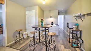 A kitchen with a round table, stools, and a hanging pot rack. - Walkout Apartment w/ Mtn View on Cortez Ranch (Cortez)