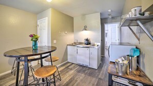 A compact kitchen with a dining area, featuring a round table, stools, a refrigerator, and a coffee maker. - Walkout Apartment w/ Mtn View on Cortez Ranch (Cortez)