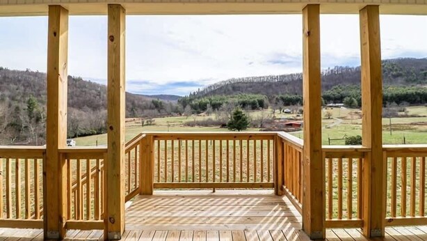 Una terraza de madera con vistas a un paisaje montañoso.