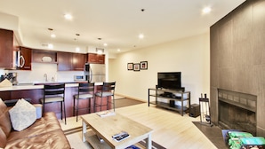 A modern living room with a wooden coffee table, a brown leather sofa, and a TV on a stand. - Spacious and Beautiful, Walk to ski, Wi-fi, Parking (Park City)