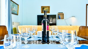 A dining table set with wine glasses, a bottle of wine, and a candle. - Alcyone, Comfortable Home Close To Athens Airport (Artemis)