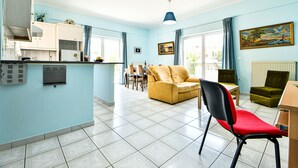 A spacious living area with a sofa, a dining table, and a kitchen area. - Alcyone, Comfortable Home Close To Athens Airport (Artemis)