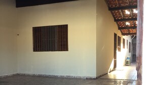 Un espace intérieur doté d’un sol carrelé, d’une fenêtre grillagée et d’une structure de plafond en bois.