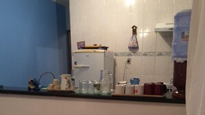 Un salon chaleureux avec un canapé beige, un coussin à motifs et un plaid blanc.