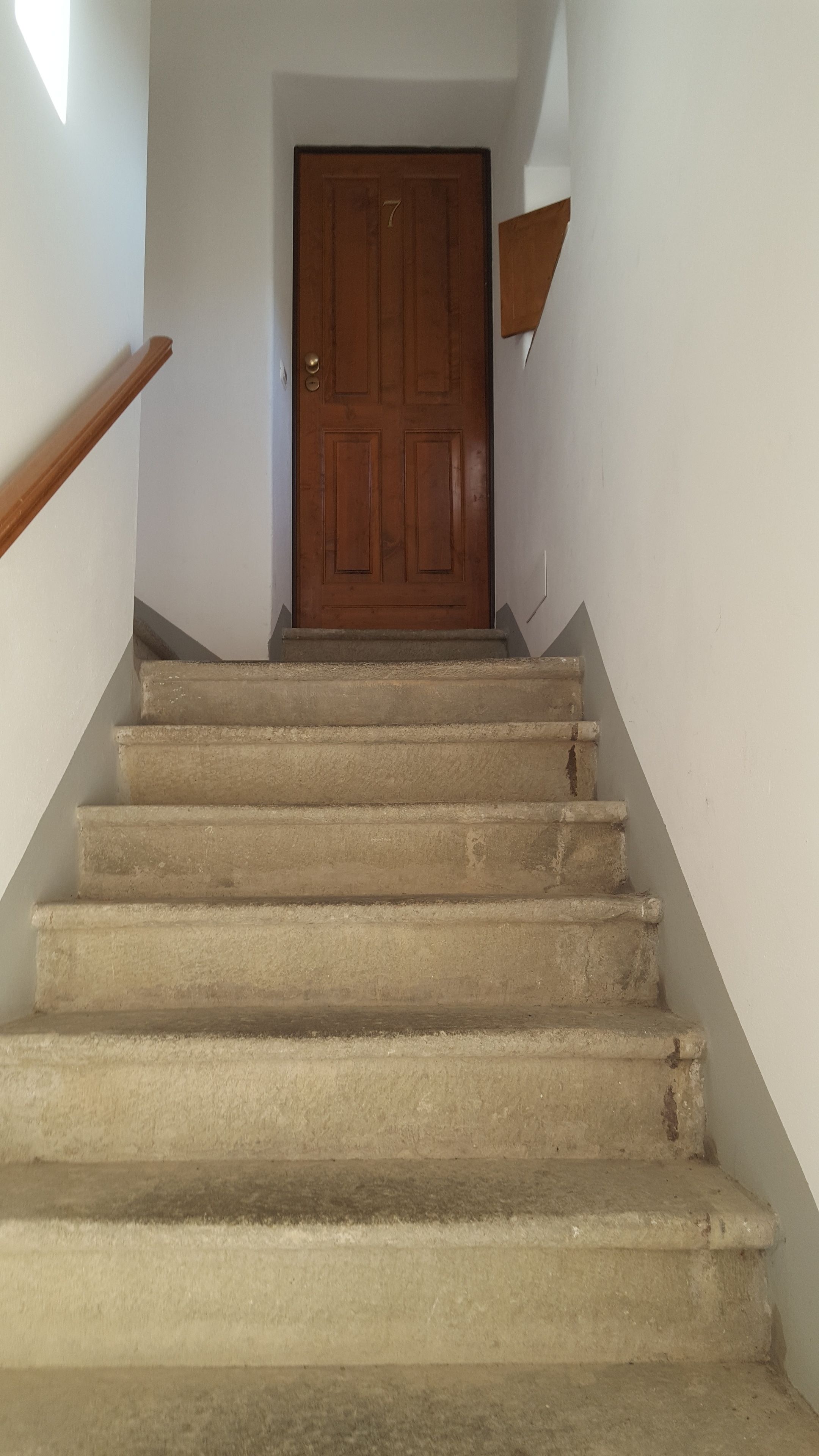 A staircase leading to a wooden door with the number 7.