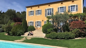 A two-story building with a swimming pool, surrounded by well-maintained gardens and trees. - Comfort double beige room (Cabriès)