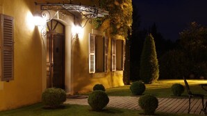 A well-lit building with a covered entrance, a paved pathway, and neatly trimmed bushes. - Comfort double beige room (Cabriès)
