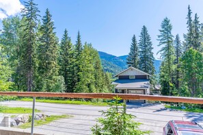 Situated in a forested area, this two-story house offers a scenic view of the surrounding mountains.