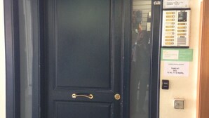A black door with a brass handle, a glass panel, and a sign indicating a dental clinic. - Vicus Apartments, with excellent views of the Plaza Mayor de Vic (Vic)
