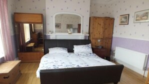 Une chambre à coucher avec un grand lit, une armoire en bois et un miroir au-dessus du lit.