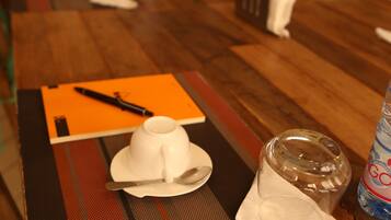 A dining table set with a white hat, a glass, and a bottle of water.
