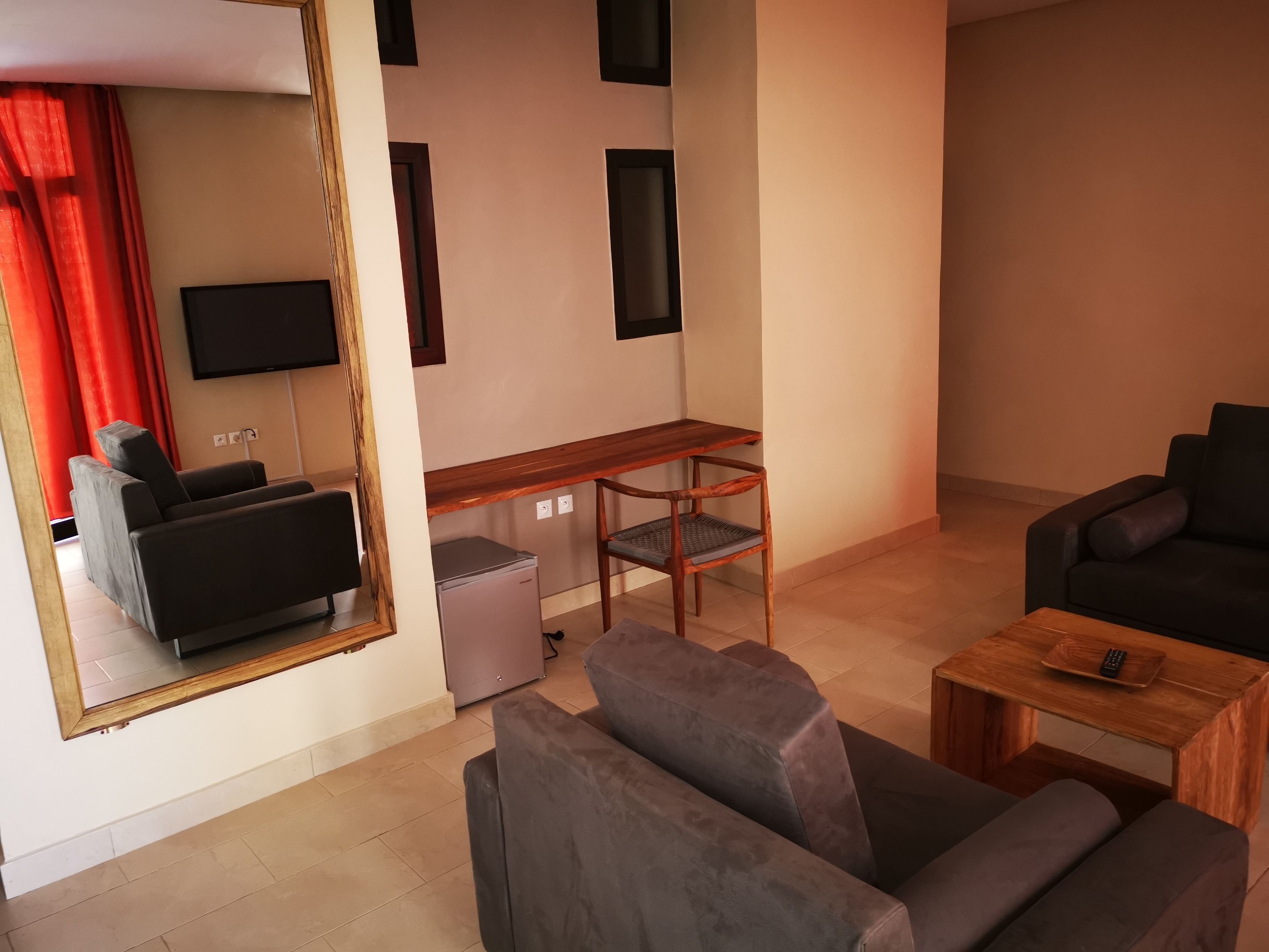 Una sala de estar moderna con un sofá, una mesita de centro, un televisor y una pequeña mesa con un control remoto.