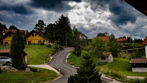 Una zona residencial con casas, una carretera sinuosa y un paisaje cubierto de césped.