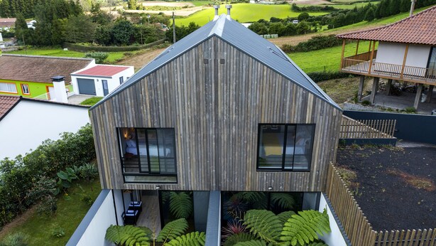 A modern two-story house with a sloped roof, large windows, and a balcony. - FURNAS HOUSES South (19A) (FURNAS)