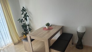 A small wooden table with a bench, a potted plant, and a decorative lamp. - Susi's Apartment - 60m2 for 2 persons, quiet location and handicapped accessible (Waldgirmes)