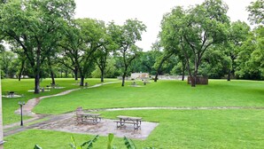 A park with picnic tables, a walking path, and a grassy area. - Good Night Sleep Tight | Guadalupe Riverfront | WiFi | Pools (New Braunfels)