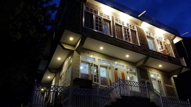 A two-story building with multiple windows and a balcony. - Hunza holiday Inn (Karimabad)