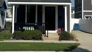 A two-story house with a front porch, a small window, and a number '225' on the door. - Perfect, Walking Distance to Downtown Social District, Grand Haven!  (Grand Haven)