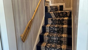 A staircase with a wooden handrail and carpeted steps. - Perfect, Walking Distance to Downtown Social District, Grand Haven!  (Grand Haven)