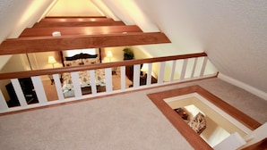 Eine Holztreppe mit weißen Geländern führt zu einem Teppichbereich.