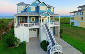 A two-story house with a balcony, a staircase, and a view of the ocean. - Luxury Beachfront Home! -Sea Sage (Galveston)