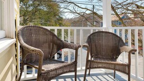 A porch with two wicker chairs and a white railing. - Walk Everywhere! Cannon St Retreat! (Charleston)