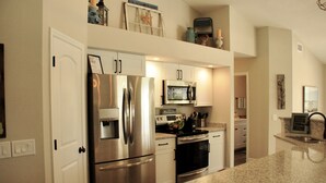 A modern kitchen with stainless steel appliances, white cabinetry, and granite countertops. - Breathtaking 3 Bedroom 2 Bath Private Pool Home in Punta Gorda FL (Punta Gorda)