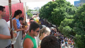 A crowded outdoor event with a large crowd gathered under a tent.