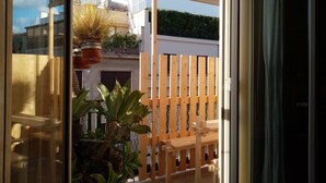 A balcony with a wooden fence, a bench, and potted plants. - Ariston (Palermo)